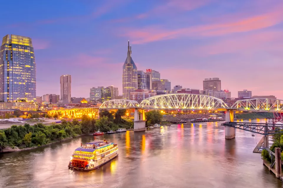 An image of Downtown Nashville with the Cumberland River at dusk.